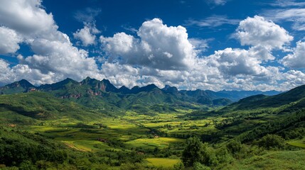Fototapeta premium Lush valley vista with dramatic mountains under a bright cloudy sky