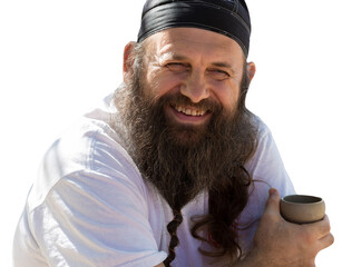 A bearded man in a bandana is drinking tea on the background of nature.