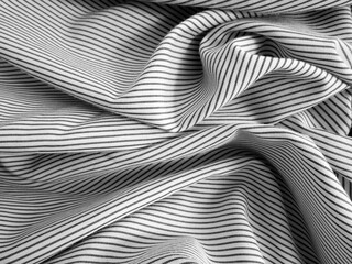 Crumpled black and white stripped fabric background. Wavy cloth texture