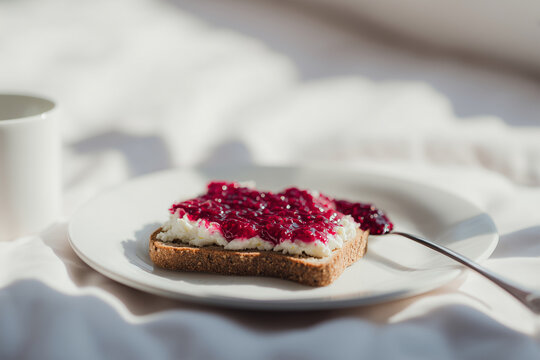 Whole grain toast topped with creamy cottage cheese and homemade berry jam. Cozy, minimalist breakfast and healthy snack scene