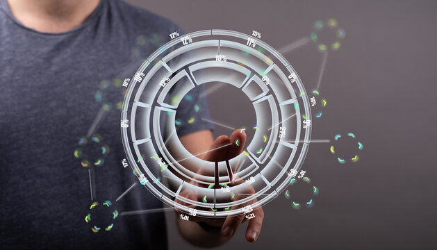 Stock photo of a person interacting with a holographic circular data interface, showing percentages and data points.