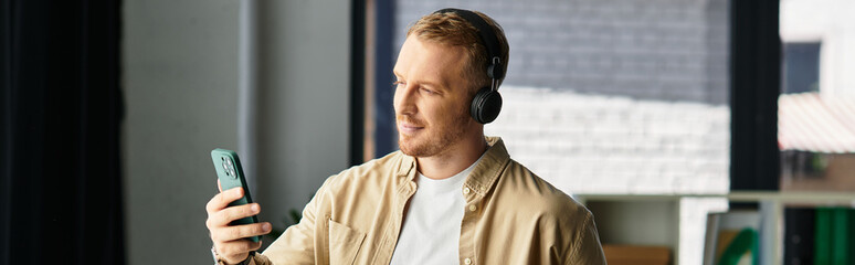 Determined young businessman engaged in work while enjoying music at his office