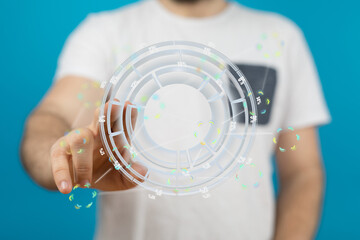 A man interacts with a holographic display showing data analytics and charts. Modern technology concept.