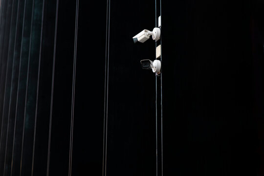 Close-up of urban security cameras on black modern building exterior