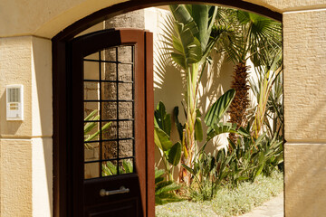 Open wooden gate reveals a vibrant tropical garden.  Perfect for travel, real estate, or vacation themes.