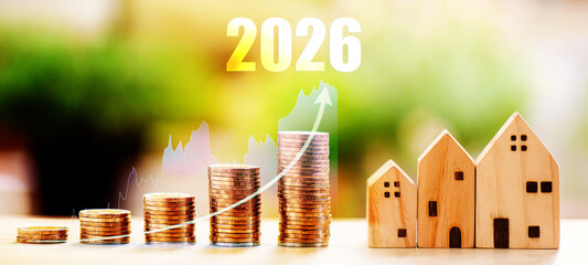 stacking coins with 2026 text on wooden table. Wooden saving word money for buying house	