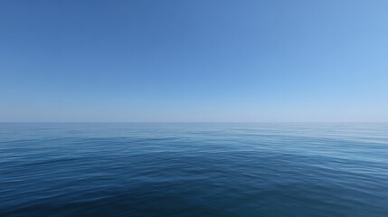 Obraz premium A wide-angle shot of blue water under a clear sky, highlighting the vast, calm sea and the unobstructed sky above.