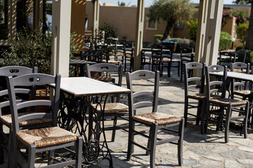 Stock photo of empty tables and chairs at an outdoor cafe on a sunny day. Perfect for restaurant, travel, or summer themes.