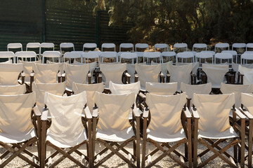 Image of rows of white folding chairs, perfect for event planning websites or articles about...
