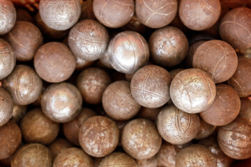 Close-up of numerous weathered metal bocce balls, showing texture and age. Perfect for sports,...