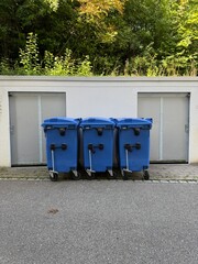 Blue trash bins are neatly positioned in the urban landscape, enhancing cleanliness