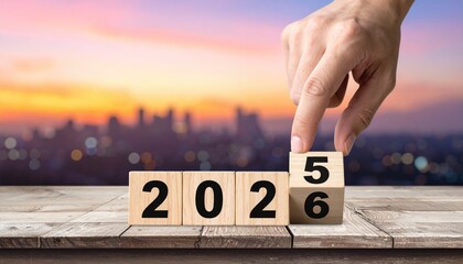 hand flipping block 2025 to 2026 text on table 