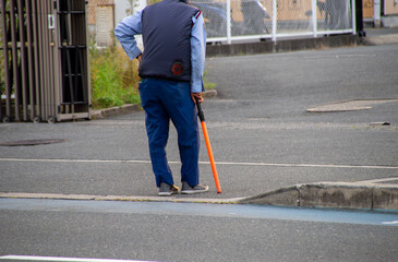 駐車場の出口で待機している高齢の誘導員
