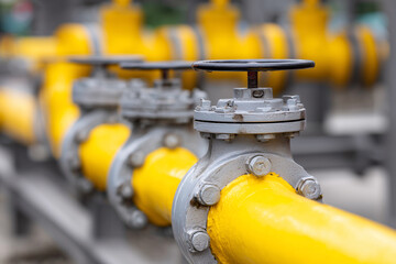 Fototapeta premium A yellow pipe with a silver valve on top