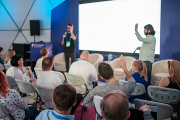 Obraz premium Group of people attending a seminar with speakers conducting an interactive session