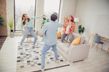Obraz premium Three Friends Dancing and Enjoying Music Together in a Comfortable Living Room on a Relaxing Day