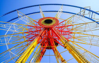 Ferris wheel illuminated at dusk with vibrant colors against a cloudy sky in a festive atmosphere