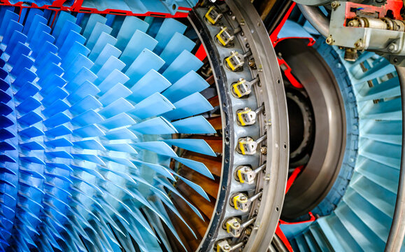Detailed view of an airplane engine showcasing its complex turbine design and colorful components during a maintenance inspection