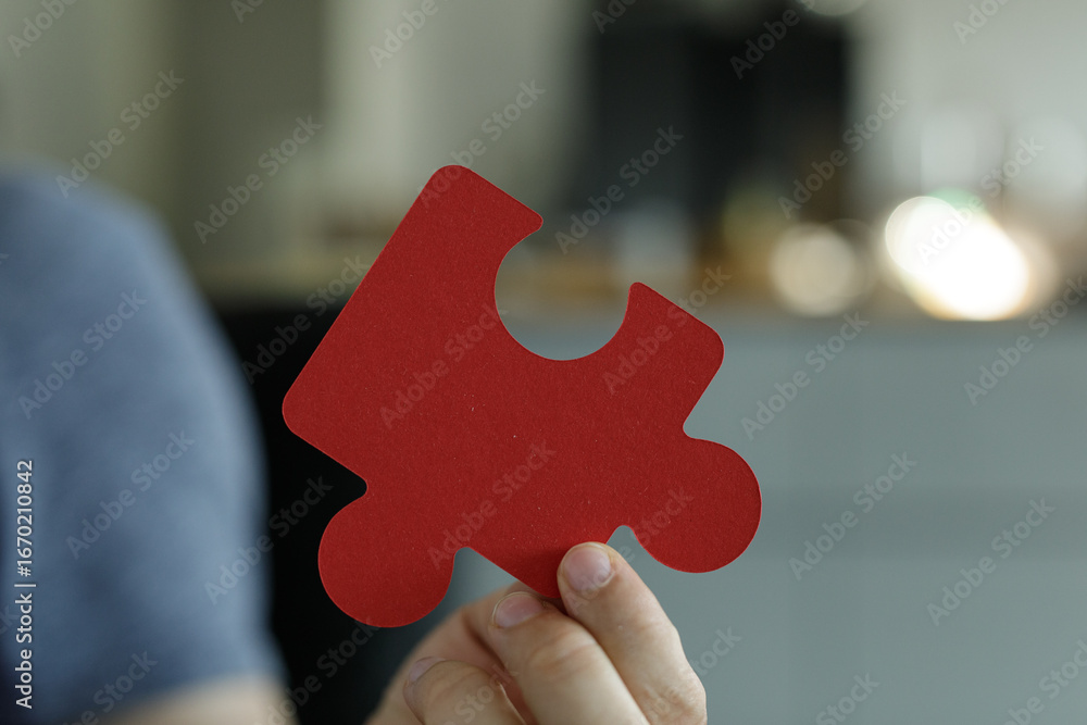 Aufkleber image of a hand holding a single red puzzle piece. perfect for concepts of solutions, teamwork, and 
