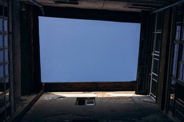 Fototapeta premium Upward view, the sky from an old inner courtyard, surrounded by building walls.