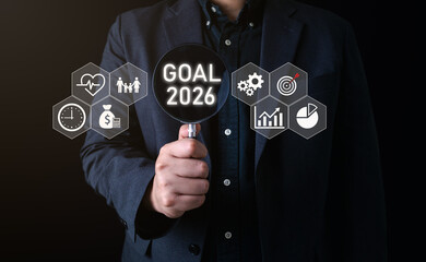 Business goal concept A businessman holds a magnifying glass showing goal 2026 surrounded by...