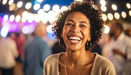 Fototapeta premium A cheerful woman smiles radiantly amid a lively celebration under festive bokeh lights at night.