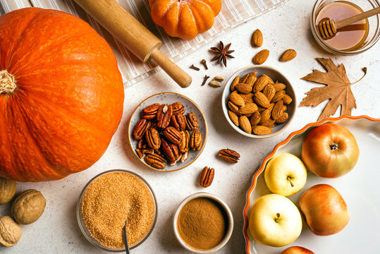 Autumn fall baking background with pumpkins, apples and ingredients