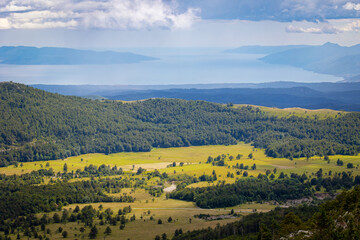 Naklejka premium Horizontal natural panorama with the forest in the foreground and the sea and coast with some islands between Slovenia and Croatia in the background.