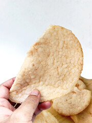 Hand Holding Fried Prawn Crackers with an Authentic Indonesian Taste