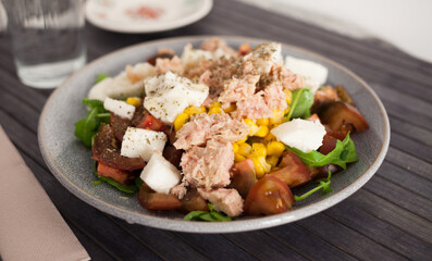 Plate of salad with tuna, corn, tomatoes and arugula