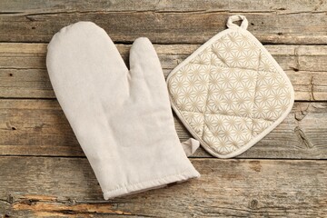 Oven glove and potholder on wooden table, flat lay