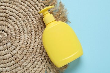 Cosmetic product and wicker mat on light blue background, top view. Mockup for design