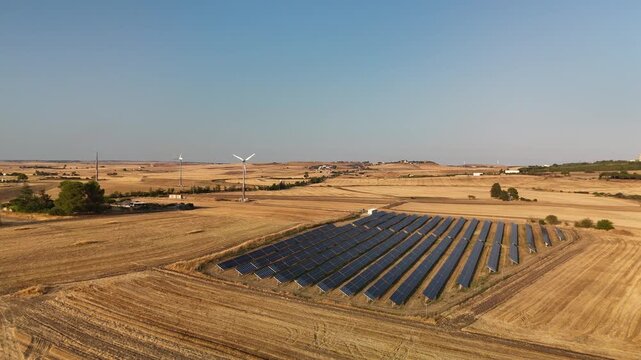 Aerial Drone View of Solar Panels and Wind Turbines in Golden Farmland near Matera, Basilicata, Southern Italy