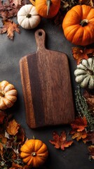 Wooden cutting board framed by autumnal pumpkins and leaves - Thanksgiving cooking preparation