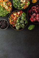 Fresh fruits and vegetables, frozen and placed in plates, on a dark backdrop, symbolizing the process of summer preparations for the colder months ahead