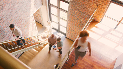Stairwell Of Busy Modern Office With Business Colleagues Meeting And Using Digital Tech
