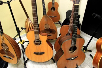 Naklejka premium A diverse collection of string instruments, including acoustic guitars and lutes, stands ready for performance