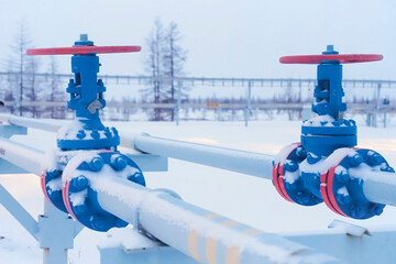shut off valves on an oil and gas pipeline, painted blue and red.