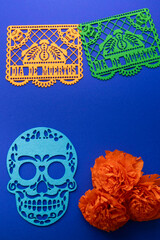 Day of the Dead altar decorations with papel picado, skull cutout and marigolds