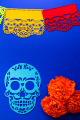Day of the Dead decorations with colorful papel picado, cut-out skulls, and marigold flowers