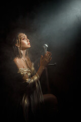 fantasy woman queen queen praying hands folded in prayer holding sword girl kneeling in dark room castle looking at ray of light hope. Black night white dress. Elf girl warrior on knees. sharp blade