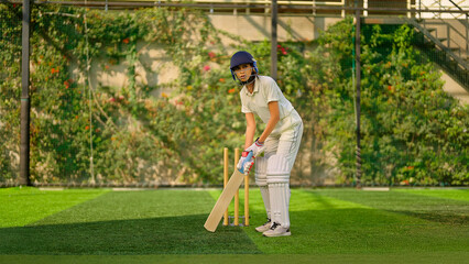 Indian young adult gen z sports woman lady standing hold bat play learn cricket match do practice to hit ball at garden angry teen female girl player wear white uniform leg guard hand gloves day time