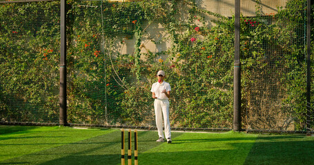 Indian young adult gen z bowler woman lady standing at match ground wear white uniform with cap. Asian teen age female girl running play cricket learn game do practice to hit wicket throw ball place