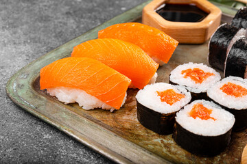 A vibrant assortment of fresh sushi, including nigiri, rolls, and sashimi on grey background close...