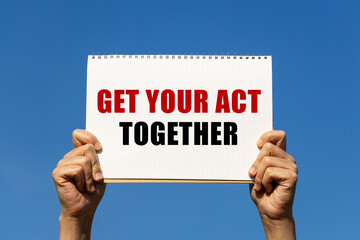 Get your act together text on paper holding by a woman's hand with blue sky background