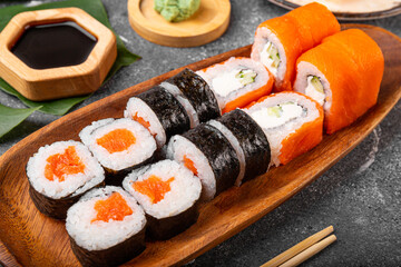 A vibrant assortment of fresh sushi, including nigiri, rolls, and sashimi on grey background close...
