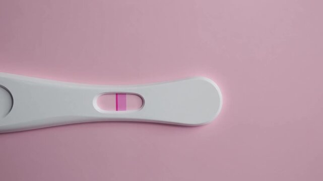 Diagnostic Device Showing Positive Indication for Pregnancy on Soft Pink Colored Background