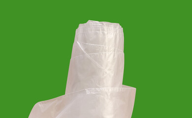 Transparent plastic sheet roll on a green background. Durable polyethylene film, often used for packaging, covering, protection and kitchen solution. Flexible and lightweight material solution.