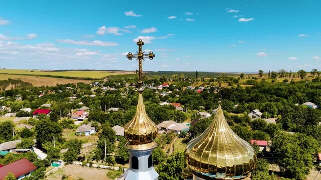 Aerial View of Moldovan Village with Blue and Gold Orthodox Church Surrounded by Lush Greenery