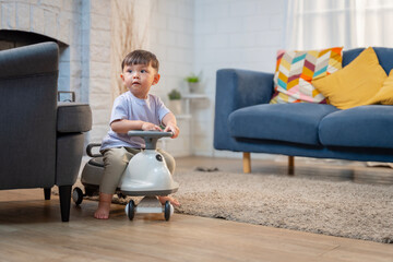 Asian boy playing with a stroller at home